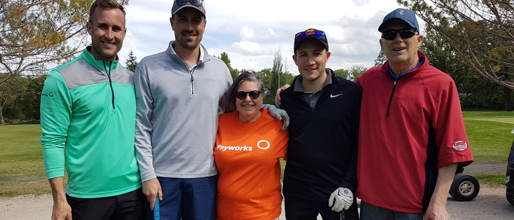 Five Payworks staff on a golf course.